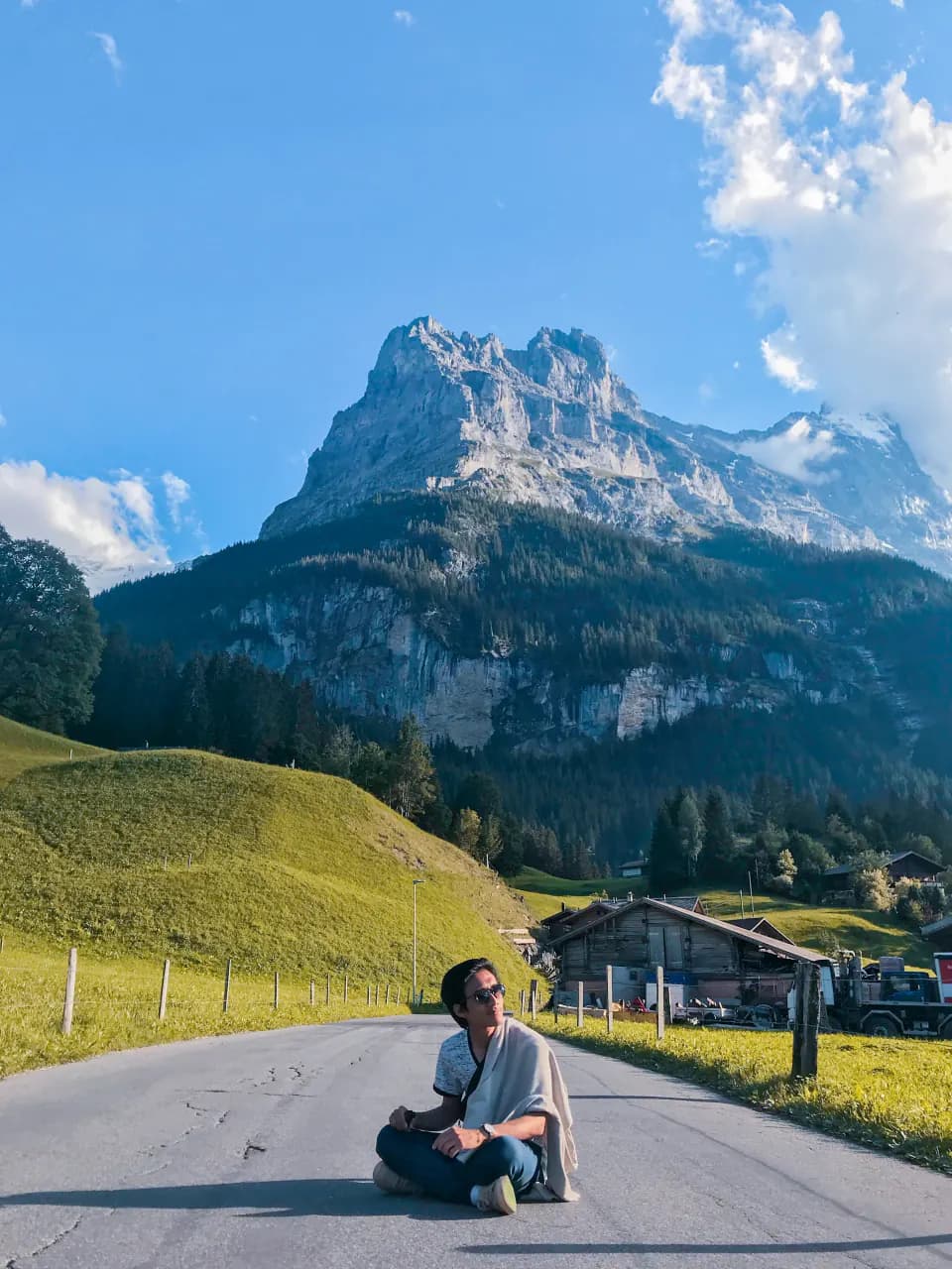 Nabil sitting on a quiet road in Grindelwald, Switzerland